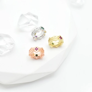Three-color geometric open rings with sparkling zircon inlay on white marble stand