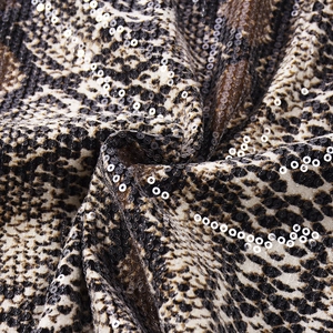 Gros plan détaillé du tissu imprimé serpent avec paillettes rondes pour hauts ajustés