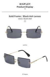 Detail view of gold metal rimless sunglasses with gradient black grey lenses