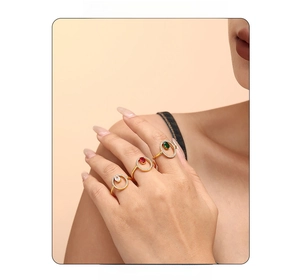 Detailed view of layered 18k gold plated rings with emerald, ruby, and diamond zircons