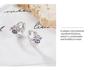 Detailed macro view of S925 silver cat paw earrings with purple heart-shaped cubic zirconia