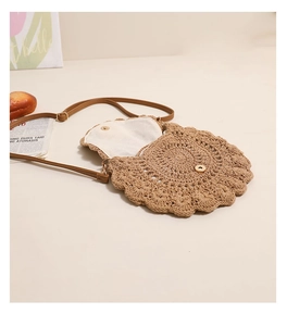 Detailed close-up of woven straw bag showing floral lace edges and magnetic closure