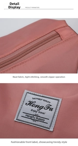 Detailed macro view of the smooth zipper and woven logo on the pink storage bag