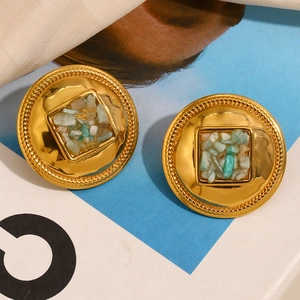 Détail de boucles d'oreilles rondes dorées 18K avec incrustation de pierres turquoise