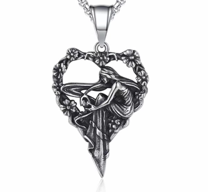 Detailed view of an antique silver angel heart pendant with floral relief engraving