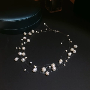 Détail d'un collier multi-rangs en perles d'eau douce avec fermoir argenté sur noir
