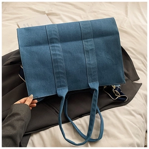 Detail of blue denim tote bag texture and sturdy stitching on white linen background