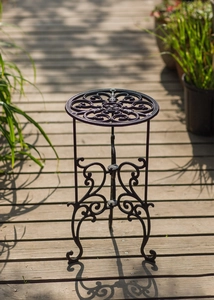 Détail d'un porte-plante en fonte vintage avec relief floral et pieds à volutes élégants