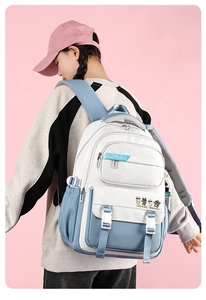 Close-up of a student backpack in blue and white on a model with a soft pink background