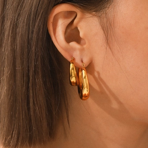 Polished 18K gold plated stainless steel teardrop hoop earrings in two sizes on model