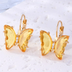 Detail macro view of crystal butterfly earrings with gold finish and lever-back hooks