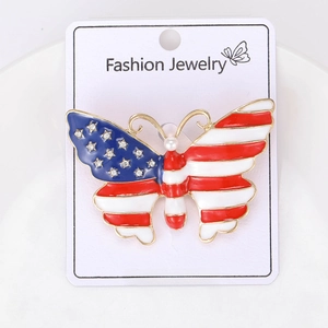 Detail of American flag butterfly brooch with rhinestones and pearl on display card