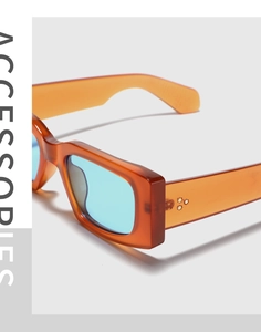 Detail of orange transparent frame with blue lenses and silver star rivet accents