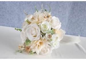 Detailed view of bridal bouquet with white roses, dahlias and white satin ribbon handle
