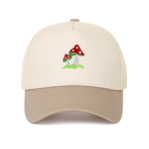 Close-up of red mushroom embroidery on a two-tone beige and khaki cotton baseball cap