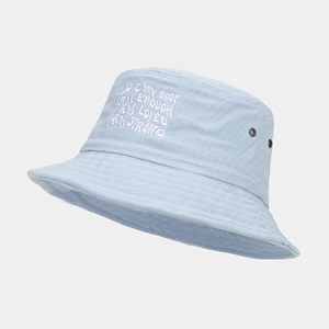 Close-up of light blue cotton bucket hat with white embroidery and metal eyelets