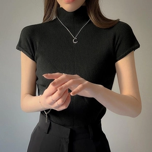 Dettaglio di un top nero in maglia a coste a maniche corte con collo alto minimalista