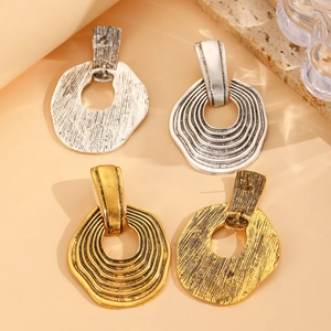 Detailed view of vintage geometric drop earrings with gold and silver hammered textures