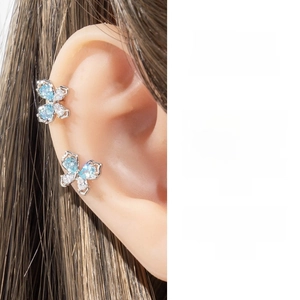 Detail shot of a silver butterfly cartilage stud with blue and clear zircon crystals
