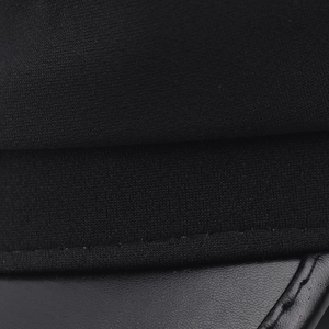 Detailed macro view showing the contrast of black knit fabric and smooth leather stitching
