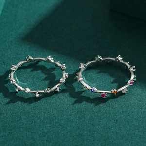 Minimalist S925 silver wavy rings with colorful zircon stones on textured green surface
