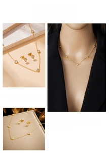 Detailed view of a gold-plated heart necklace and stud earrings set with clear zircon