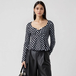 Top aderente a pois con scollo a V da donna abbinato a pantaloni in pelle a vita alta