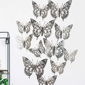 Detailed silver hollow butterfly wall stickers with intricate laser-cut patterns on white wall