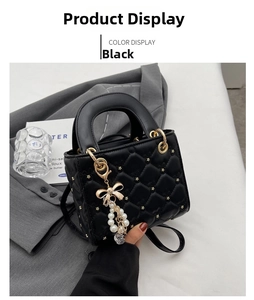 Detailed view of black quilted handbag with gold star studs and pearl bow charm accessory