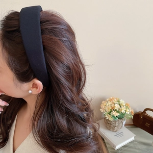 Detail of a wide black fabric headband on model with elegant minimalist velvet texture
