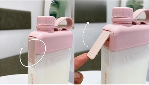 Detail showing the flip-up lid mechanism and pink matte finish of the square water bottle