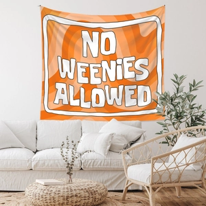 Detail of bohemian orange tapestry with No Weenies Allowed text in a bright living room