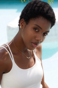 Detail of white half-moon pendant necklace and matching earrings on a model