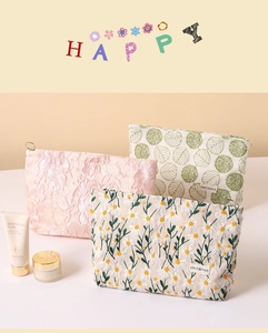 Detailed set of three embroidered canvas makeup bags with floral patterns and zippers