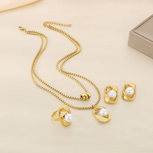 Golden stainless steel jewelry set with pearls featuring necklace, earrings, and ring