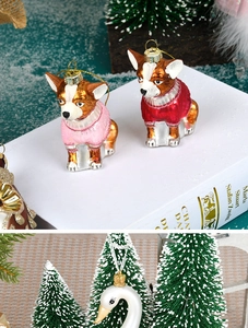 Detailed view of hand-painted glass chihuahua and swan ornaments on a snowy background