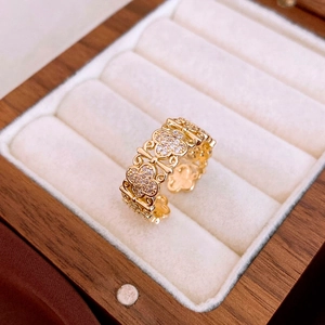 Detail of gold open ring with clover motif and pavé cubic zirconia in a jewelry box