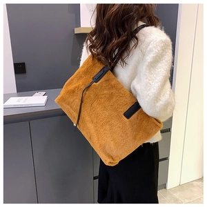 Dettaglio della borsa tote in peluche marrone caldo con tracolla in pelle nera per l'inverno