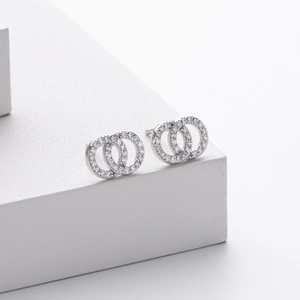 Macro shot of silver stud earrings featuring interlocking rings set with pavé zircons