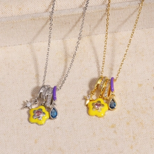 Detail of gold and silver enamel necklaces with colorful zircon heart and flower pendants