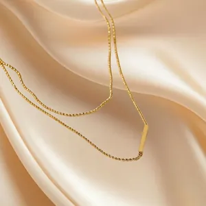 Minimalist double layer T-bar pendant necklace in 18K gold finish on elegant satin background