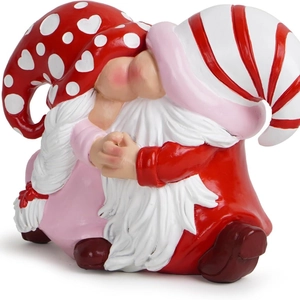 Close-up of kissing Valentine's garden gnomes figurines with heart patterns in red and pink