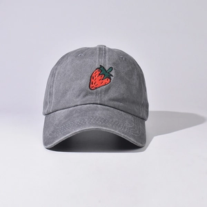 Dettaglio del ricamo a fragola su cappellino da baseball in cotone lavato grigio
