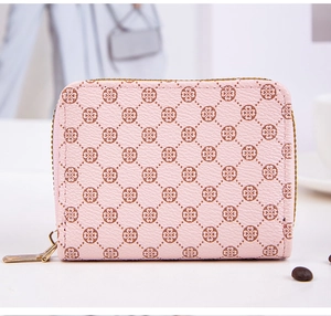 Close-up of pink leather wallet with quilted clover pattern and golden metal zipper