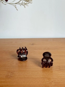 Detailed view of handmade tortoise shell acetate hair claws on a light wood background