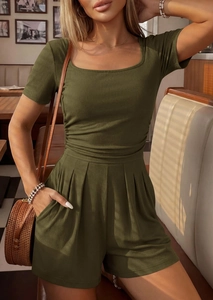 Detail of dark green ribbed knit jumpsuit featuring a modern square neckline and fabric texture
