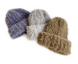 Detail of plush knitted beanies in purple, light grey, and camel for autumn winter