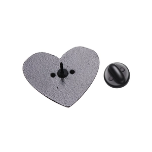 Detail view of the black heart-shaped metal backing and rubber clutch for enamel pins