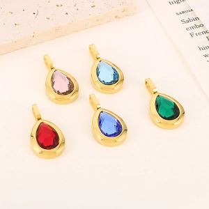 Five colorful teardrop crystal pendants in gold settings on a minimalist beige background