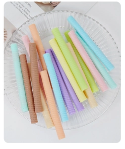 Macro shot of colorful PVC spiral wafer stick props on a striped glass plate